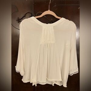 White blouse with lace sleeve hem and pearl detail at hem. Size Medium